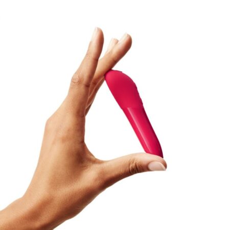 Hand holding a cherry Red colored We-Vibe Tango X bullet vibrator diagonallyÂ on a white background