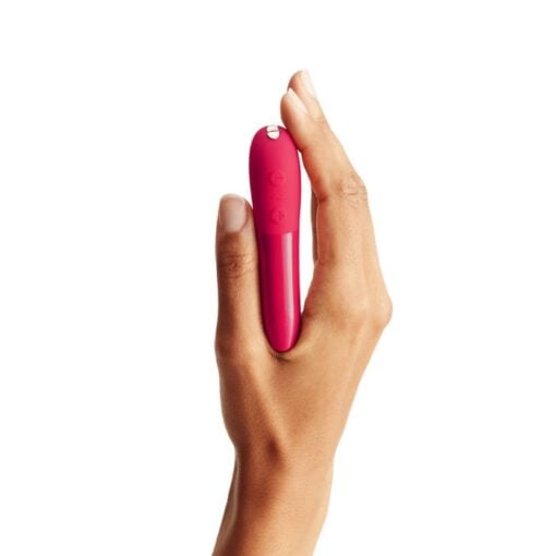 Hand holding a cherry Red colored We-Vibe Tango X bullet vibrator straight up on a white background