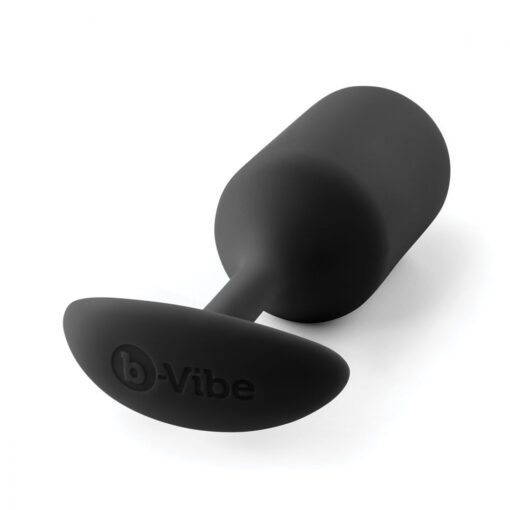 Large sized, black Snug Plug butt plug covered withÂ  silicone laying on its side on a white background